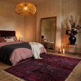 Load image into Gallery viewer, A styled bedroom interior featuring a bed dressed in dusty pink and charcoal bedding, a large deep burgundy area rug in the foreground, a tall floor mirror, candles, a woven pendant light, and a black vase with dried pampas grass against textured beige walls.
