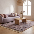 Load image into Gallery viewer, A cozy living room scene featuring a mauve-purple textured area rug with fringe, styled with a light wood coffee table, a lavender bouclé sofa, and neutral-toned decor.
